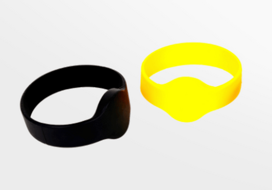 Ett par RFID Silikonarmband med MiFare Ultralight EV1 armband i svart och gult på en vit yta.